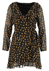 Černé zavinovací šaty s dlouhými průhlednými rukávy, s volánkovým výstřihem a žlutým květinovým vzorem. Rozšířený lem s vázaným pasem.