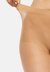 Ropa interior nude sin costuras con una delgada cinturilla elástica. La textura es transparente y suave, diseñada para brindar comodidad y un ajuste discreto.