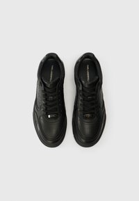 Paar schwarzer Leder-Sneaker von Karl Lagerfeld mit durchlüfteten Zehenkappen, Schnürfront und Branding auf Zunge und Seite, von oben gezeigt.