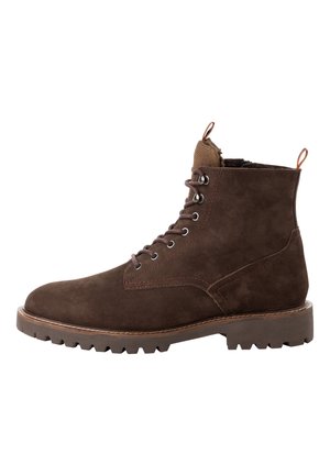 Brown suede ankle boot with a rounded toe, 6 eyelets, and a rubber lug sole. Features a fabric collar and rear pull tab. Detailed stitching.