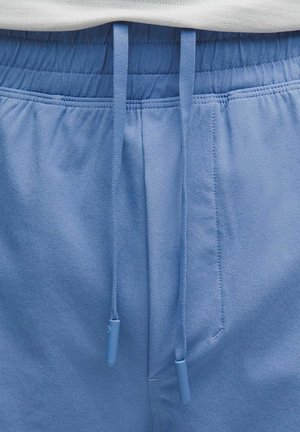 Lichtblauwe joggingbroek met elastische tailleband en bijpassende blauwe trekkoorden die losjes aan de voorkant hangen.