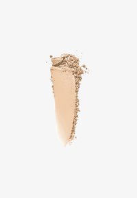 Beige puderfoundation swatch med en jämn textur och en lätt matt finish, åtföljd av lösa puderpartiklar på ena sidan.