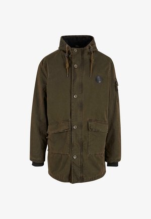 Olivengroene parka jas met capuchon, sluiting met knopen aan de voorkant, twee grote zijzakken en een ritszak op de mouw. Fleece voering zichtbaar.