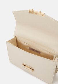 Pochette beige con texture liscia, chiusura con dettagli in metallo dorato, tasca interna e etichetta con la scritta "ANNA FIELD."