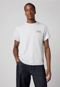 Grijze katoenen T-shirt met een ronde hals, korte mouwen en een gestikte multicolor logo-detail op de borst. Casual pasvorm en een gladde textuur.