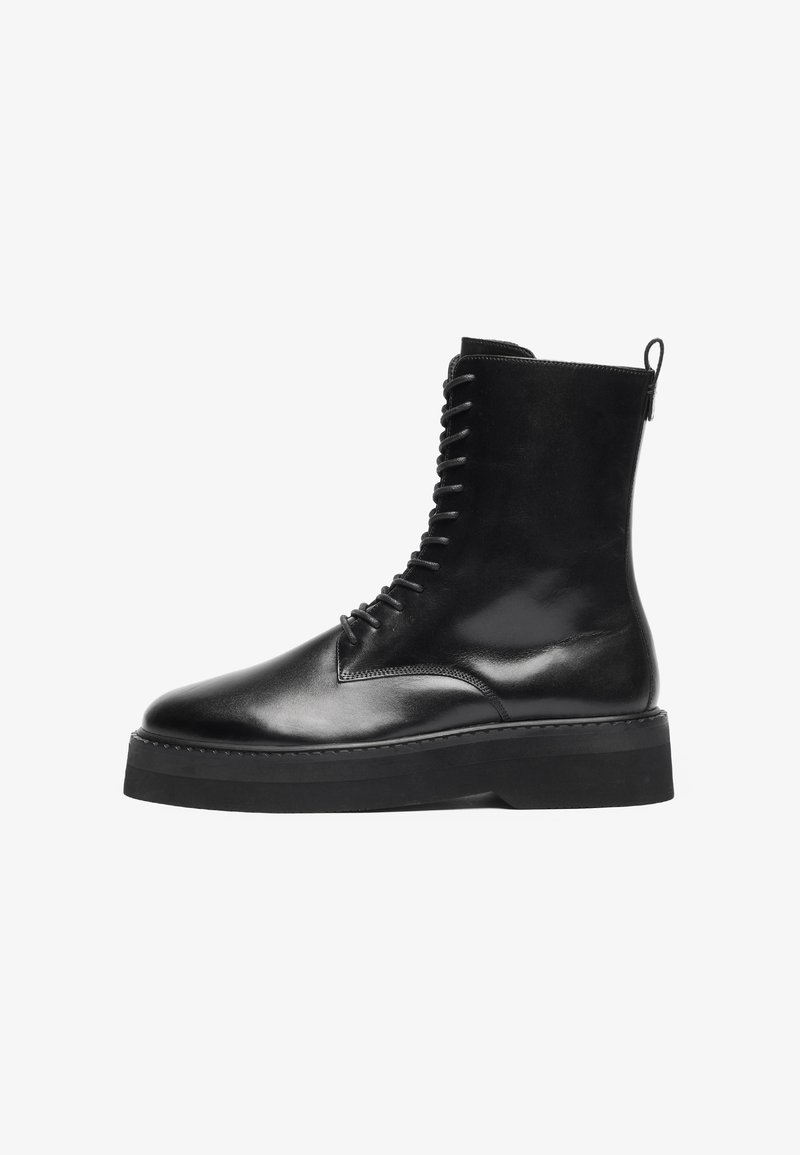 Botine negre din piele cu vârful rotund, șireturi frontale și o talpă chunky neagră. Textură netedă cu o bandă de prindere la spate.
