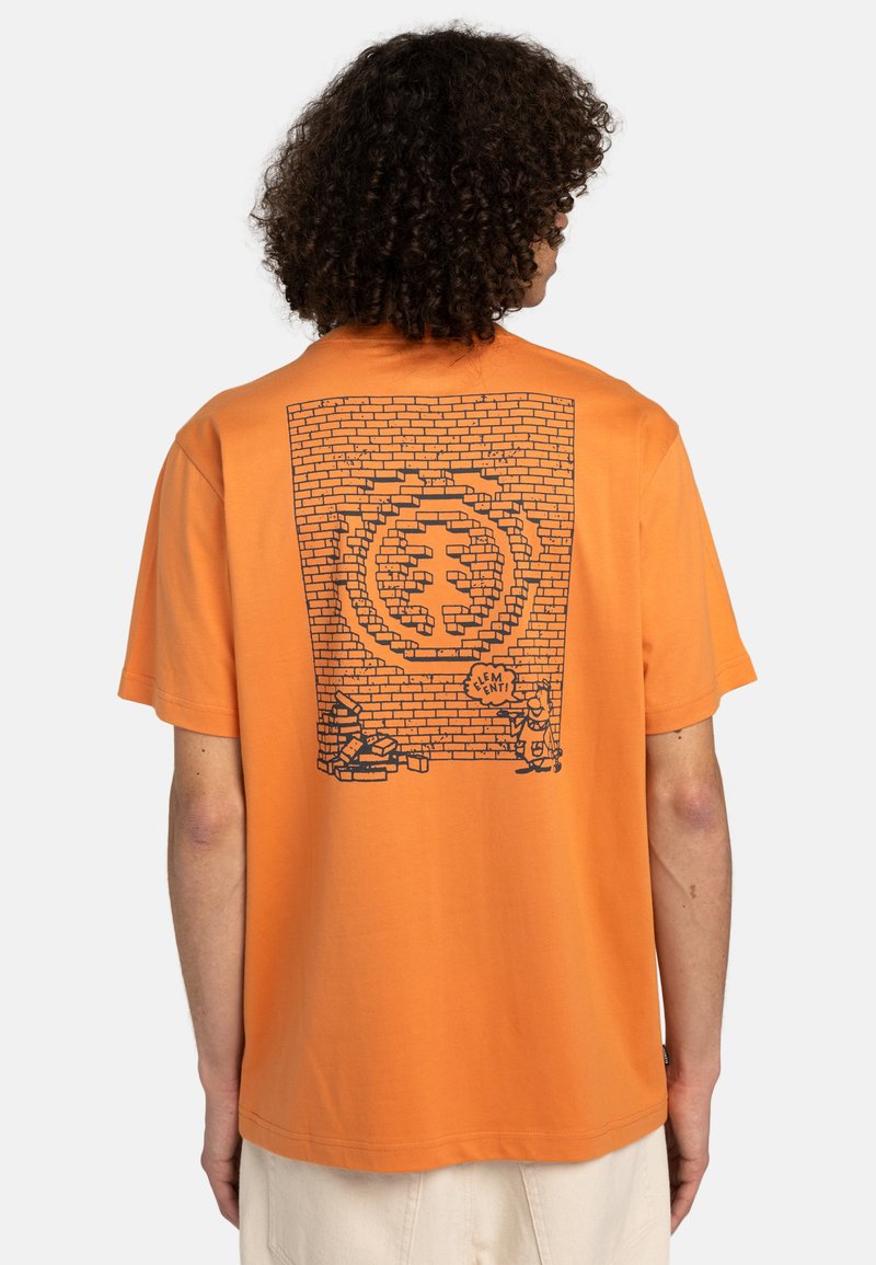 Pomarańczowy t-shirt z krótkim rękawem z czarną grafiką przedstawiającą ceglaną ścianę oraz rysunkowe postacie i tekst na plecach. Wykonany z miękkiej bawełny.