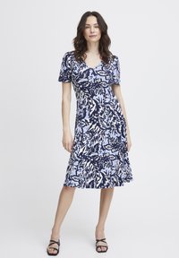 Lyhythihainen mekko, jossa on tummansininen ja vaaleansiniset kukkakuviot. Valmistettu pehmeästä kankaasta, jossa on muotoiltu yläosa ja levenevä helma.