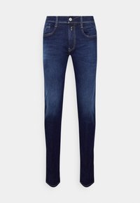 Jeans de mezclilla azul oscuro con un corte ajustado, que presentan un diseño clásico de cinco bolsillos, costuras en dorado y un cierre de botón en la cintura.