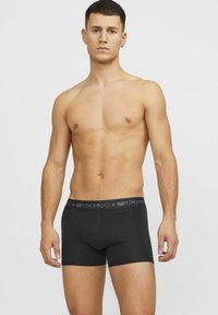Zwarte boxershorts van zacht, rekbaar materiaal met een elastische tailleband en een grijze logo-opdruk. Gemaakt voor comfort.