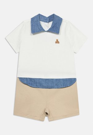 Top alb cu mâneci scurte, guler albastru și detaliu la tiv, ursuleț brodat, asortat cu pantaloni scurți bej pentru toddler.