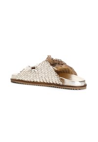 Woven sandals with metallic gold and brown hues, featuring a textured strap and flat sole, accented with fringed detailing and a chain.