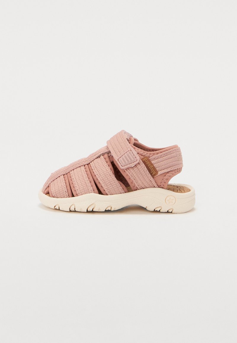 Sandálias de tecido rosa com um design texturizado, bico aberto, tiras ajustáveis e uma sola de borracha de cor creme com um padrão de ranhura.