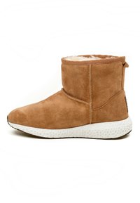 Brune ruskinds ankelstøvle med blød foring, rund tå, elastisk krave og tekstureret hvid sål. Har stikningsdetalje og en trækkrog.