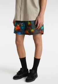 Die Badehose hat ein lebhaftes, mehrfarbiges abstraktes Muster in Blau-, Grün-, Orange- und Rottönen. Sie besteht aus leichtem Material und hat ein mittellanges Design.