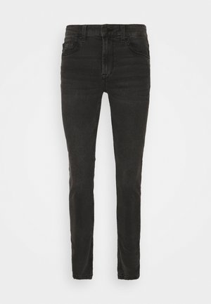 Black skinny jeans made of denim, featuring a high waist, five-pocket design, and minimalistic stitching. Smooth texture with a clean finish.