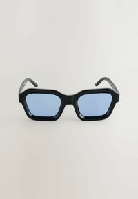 Ochelari de soare negri supradimensionați cu lentile dreptunghiulare, având sticlă tintată în albastru și un finisaj lucios. Combinația are un design masiv.