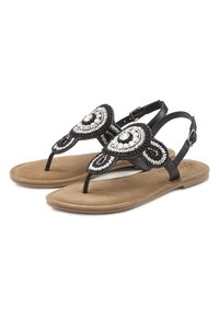 Sandali neri con perline e design floreale, dotati di un inserto per le dita dei piedi e una cinghia regolabile alla caviglia. Soletta morbida simile al camoscio in tonalità beige e suola minimalista.