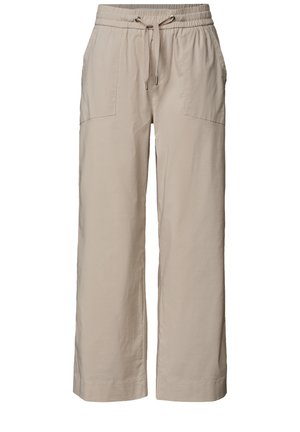 Pantalon beige à taille élastique avec cordon et poches latérales, porté avec une chemise blanche texturée à manches longues et un top blanc.