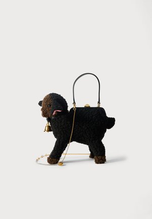 Svart och brun plyschhandväska formad som en hund, med en gyllene klocka, kedja och ett handtag i svart läder. Texturerad, mjuk yta.