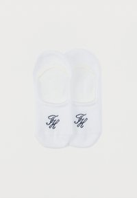 Άσπρες βαμβακερές κάλτσες αστραγάλου με ριμπ μανσέτες και κεντημένα ναυτικά μονογράμματα στο πλάι. Λείο ύφασμα και σχεδιασμός χαμηλής κοπής για διακριτική χρήση.