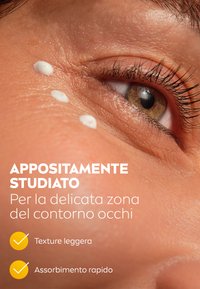 Primo piano della pelle attorno all'occhio con puntini di crema bianca su una superficie liscia. Le caratteristiche includono un tono della pelle naturale e ciglia dettagliate.