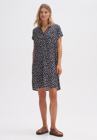 Kurzes Kleid aus leichtem Stoff, marineblau mit weißen und rosa Punkten, kurze Ärmel, durchgehende Knopfleiste und lockere Passform.