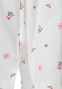 White fabric with a flower pattern in pink, blue, and green. Features small decorations, including hearts and floral motifs. Soft texture.