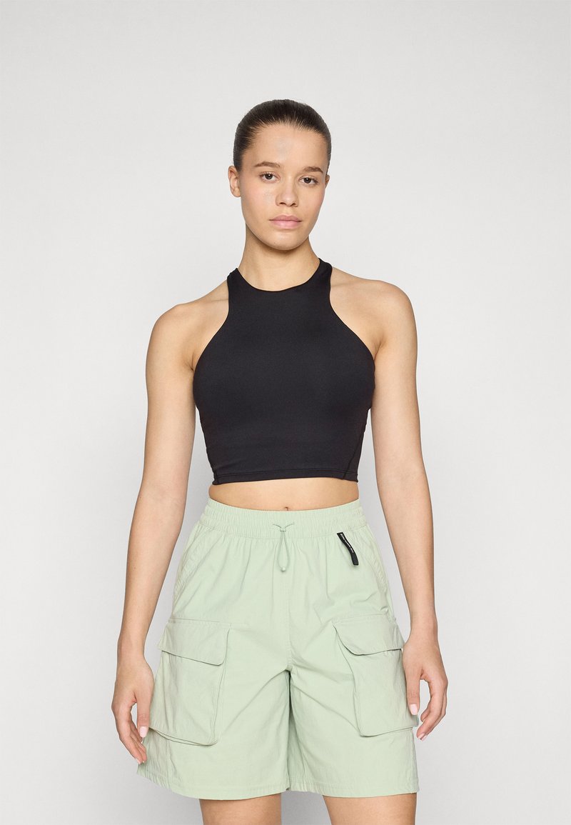 Must mustakangas crop top mustana, mis on koos heledate roheliste cargo-shortsidega, millel on elastne vöökoht ja kaks küljetaskut. Sile tekstuur, juhuslik disain.