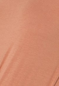 Tecido em tom pêssego suave, textura lisa, ligeiramente elástica. O material parece leve com um brilho subtil. Sem padrões ou acessórios.