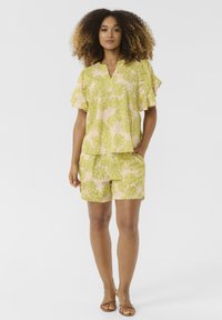 Set di camicia e pantaloni corti con stampa floreale gialla, caratterizzato da motivi di foglie verdi, maniche corte a volant e vestibilità comoda, realizzato in tessuto leggero.