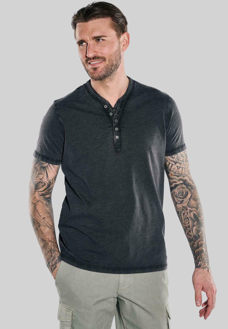 Dark gray cotton henley shirt with short sleeves, five-button placket, and a ribbed collar. Features visible stitching and relaxed fit.