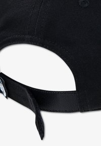 Μαύρο καπέλο με υφασμάτινη υφή, διαθέτει κυρτή γείσο και ρυθμιζόμενο λουράκι στο πίσω μέρος με ετικέτα λογότυπου.