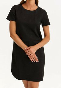 Robes noires à manches courtes avec un col rond, texture lisse, conception mi-genou et ourlet arrondi. Silhouette simple et épurée sans motifs.