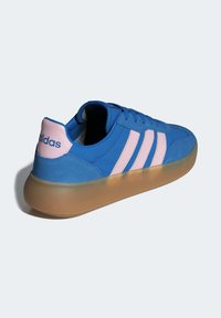 Plave tenisice s ružičastim tri pruga i naglascima na peti, s teksturiranim gornjim dijelom i prozirnim, svijetlo smešnim potplatom.