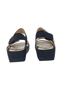 Sandali wedge neri con retro aperto, cinturini regolabili e suole lisce.Parte superiore in tessuto testurizzato con un design geometrico e hardware minimale.