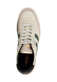 White sneaker with green stripes, lace-up design, perforated toe, and black interior. Features gold logo on insole. Smooth leather texture.