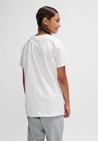 Hvid bomulds t-shirt med en klassisk rund hals, korte ærmer og en afslappet pasform, parret med grå sweatpants.