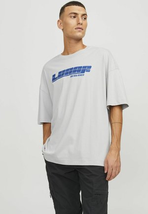 Lichtgrijs katoenen t-shirt met een blauwe grafische print met de tekst "LUNAR JACK & JONES." Loose fit met korte mouwen en een ronde hals.