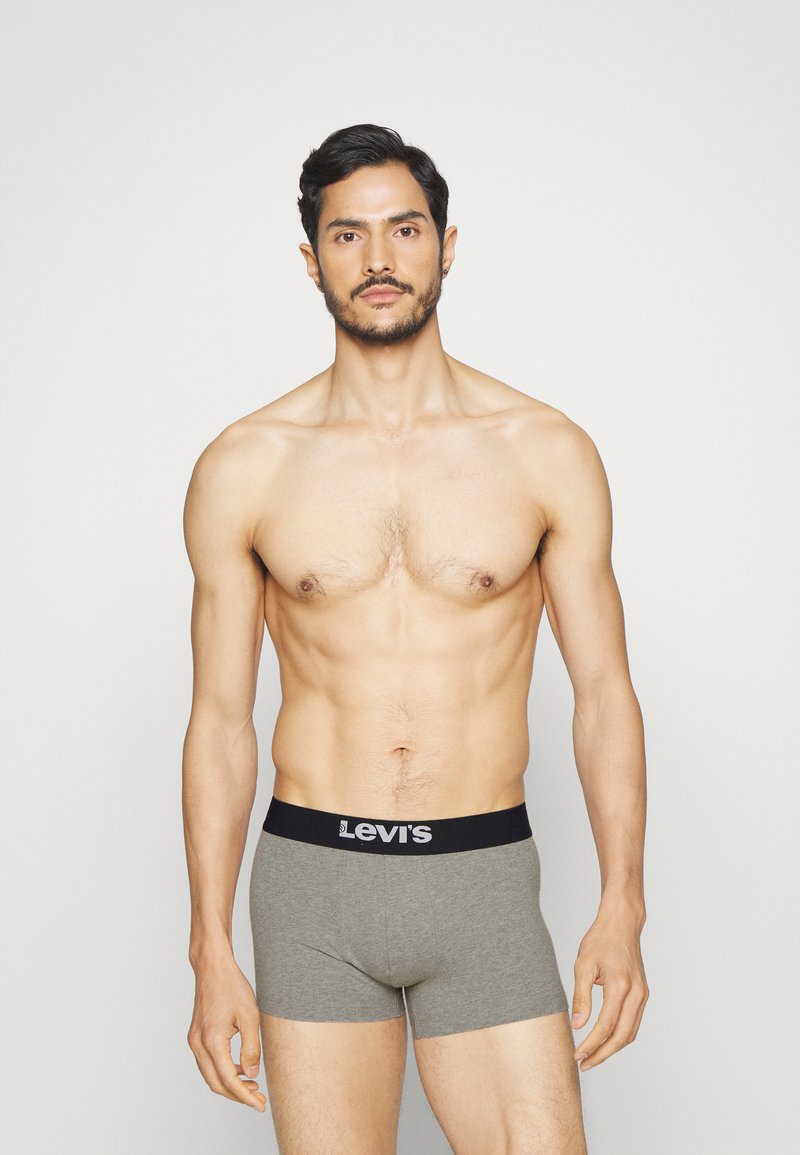 Levi's harmaan väriset puuvillabokserit, joissa on musta vyötärö, jossa on brändin logo. Malleja, jotka esitellään yksinkertaista taustaa vasten.