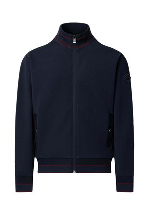 Granatowa kurtka zapinana na zamek z stojącym kołnierzem, czerwonymi paskami na kołnierzu, mankietach i dole oraz kieszeniami na bokach z zapięciem na zatrzaski.