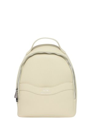 Zaino in pelle beige testurizzata con una forma arrotondata, cerniera frontale e maniglia superiore. Presenta un branding discreto sul fronte.