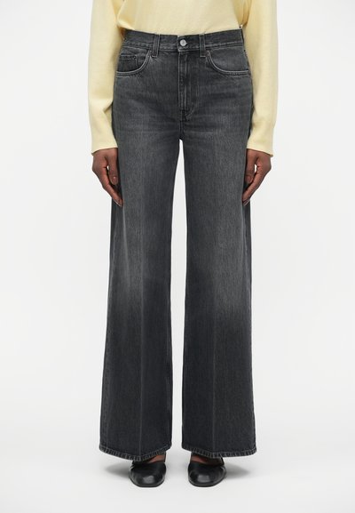 Jeans taille haute, à jambe large en denim gris foncé, dotés de poches avant, d'une couture contrastante et d'une texture légèrement délavée.