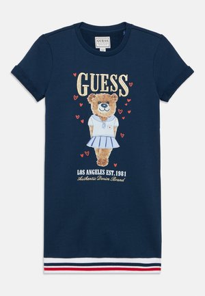 Ναυτικό μπλε φόρεμα με κοντά μανίκια, με γραφικό αρκούδας σε λευκό φόντο, με χρυσές και κόκκινες λεπτομέρειες, και ριγέ τελείωμα σε κόκκινο, λευκό και μπλε.