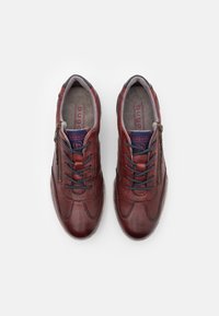 Scarpe in pelle marrone con dettagli testurizzati, dotate di lacci e una cerniera laterale. L'interno è rivestito in tessuto grigio e presenta dettagli di branding.