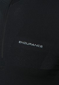 Svart atletisk top med en texturerad design och en kvartzip-stängning. "ENDURANCE"-logotyp i ljusblått på vänster sida.