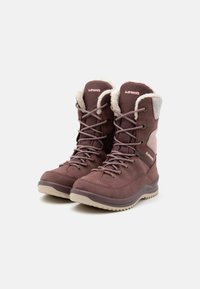Braune Wildleder-Winterstiefel mit Kunstfellkragen, Schnürsenkeln und Gummisohlen. Sie verfügen über seitliche Akzente und ein Logo auf der Zunge.