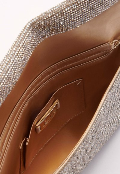 O poșetă de mână metalică cu strasuri argintii lucioase, căptușeală netedă bej, compartiment interior și etichetă cu accesorii aurii.