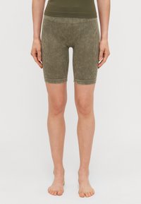 Shorts de vélo en velours côtelé vert olive avec une taille ajustée, un design à mi-genoux et des rayures verticales, offrant une texture douce et des bords sans couture.
