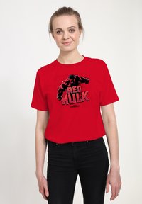 Red cotton T-shirt featuring a graphic print of the Red Hulk character, black lettering, round neckline, and short sleeves.
